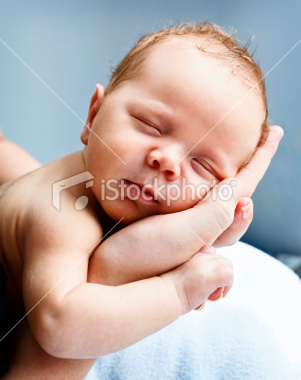 stock-photo-20103303-blissfully-sleeping-baby-cradled-in-mothers-hands